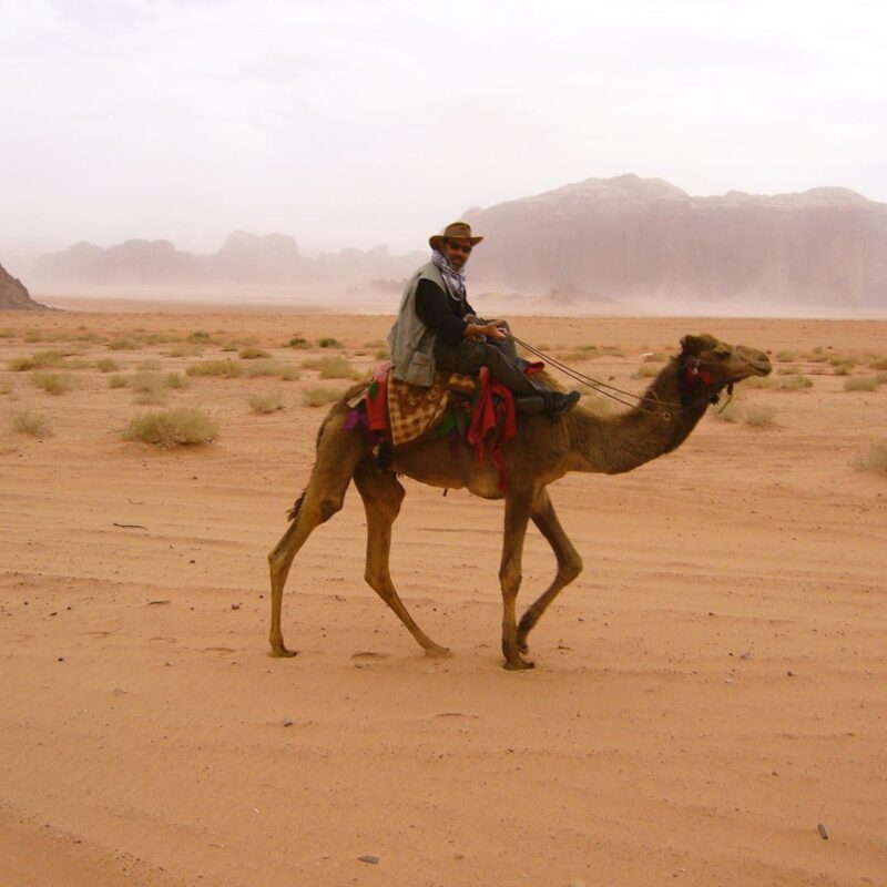 Bruce riding a camel in Wadi Rum desert in Jordan